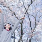 桜の木の下で喜ぶ女子高生